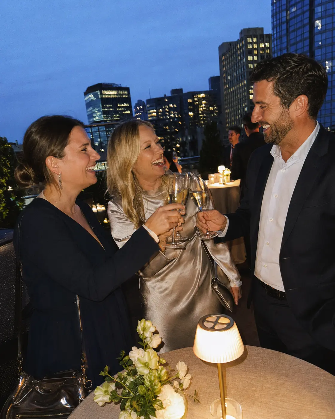 Three friends making a toast on a city rooftop